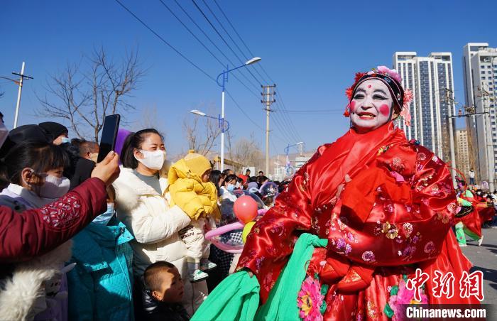 图为社火队演员正在与观众互动。　马铭言 摄