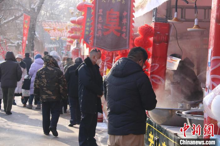 乌鲁木齐市民在公园小吃摊上选购食品。　潘琦 摄